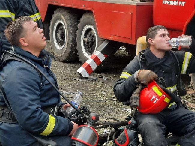 This handout picture released by the State Emergency Service of Ukraine on June 13, 2023, shows firefighters taking a rest as they extinguish a fire on a five-storey residential building, the site of a night Russian strike, in the city of Kryvyi Rig, amid the Russian invasion of Ukraine. Three people were killed and 32 wounded in a Russian missile strike on the central Ukrainian city of Kryvyi Rih early June 13, 2023, the regional governor said, as air attacks were reported in Kyiv and other cities. "A five-storey building got destroyed. According to initial reports, three of its residents died. 25 people were injured," Serhiy Lysak, governor of Dnipropetrovsk region, said on Telegram. (Photo by Handout / THE STATE EMERGENCY SERVICE OF UKRAINE / AFP) / RESTRICTED TO EDITORIAL USE - MANDATORY CREDIT "AFP PHOTO / THE STATE EMERGENCY SERVICE OF UKRAINE  " - NO MARKETING NO ADVERTISING CAMPAIGNS - DISTRIBUTED AS A SERVICE TO CLIENTS