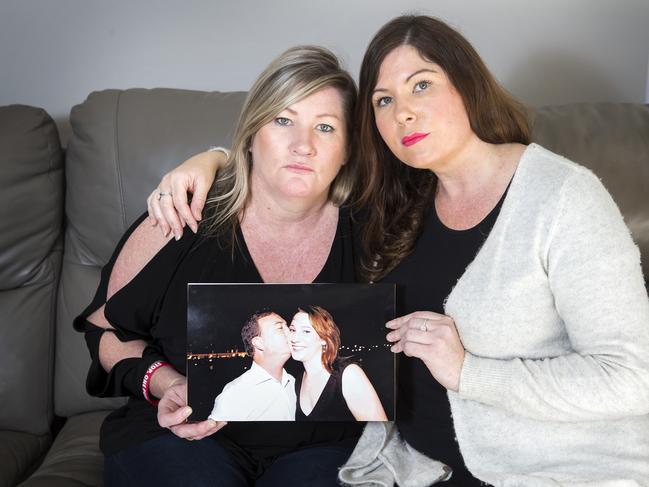 Maria Aylward and her sister Katelyn Aylward with a picture of their sister Korinne and her partner Greg Tucker, who where both murdered in 2013. Picture: Sarah Matray