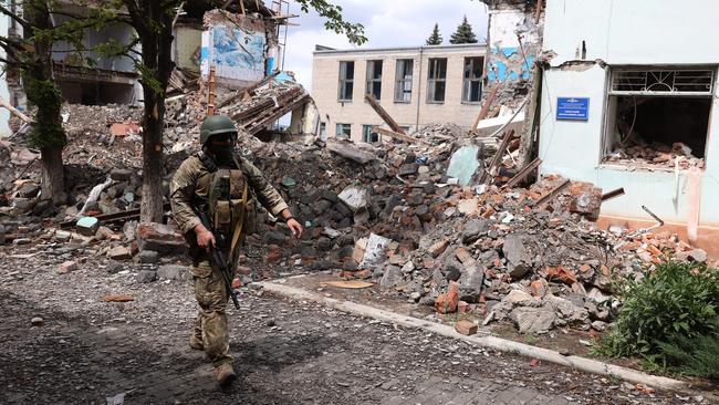 A Ukrainian serviceman passes destroyed buildings in the town of Siversk, Donetsk region. Picture: AFP