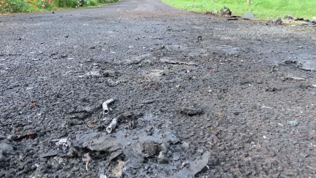 Nick Skrinnikoff’s driveway has been left with melted bitumen, shattered glass and a destroyed fence. Picture: Arj Ganesan