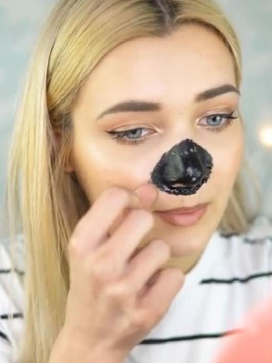 A woman peels off the blackhead mask.