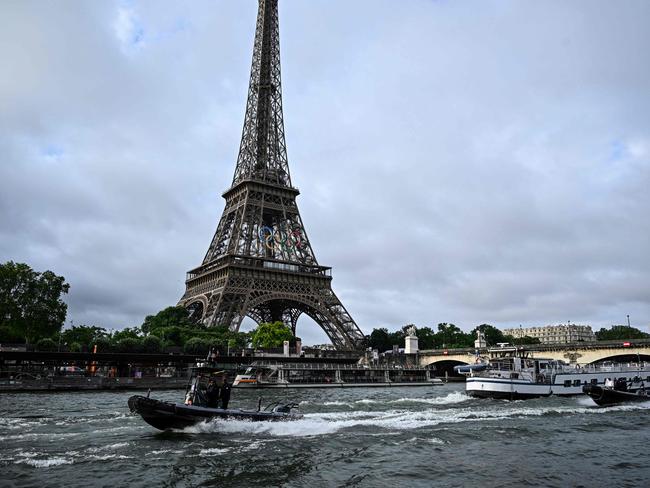 (FILES) Police boats participate in a technical navigation rehearsal on the Seine river for the opening ceremony of the Paris 2024 Olympic Games, in Paris, on June 17, 2024. The Seine river was too dirty when it was tested on June 16 to allow the Olympic triathlon and open water swimming competitions to take place, the results of an analysis showed on June 21, 2024. "The samples taken from the Seine do not meet the standards we will have this summer" for the river for the Paris 2024 Olympic Games, from 26 July to 11 August, said Paris region prefect Marc Guillaume. (Photo by JULIEN DE ROSA / AFP)
