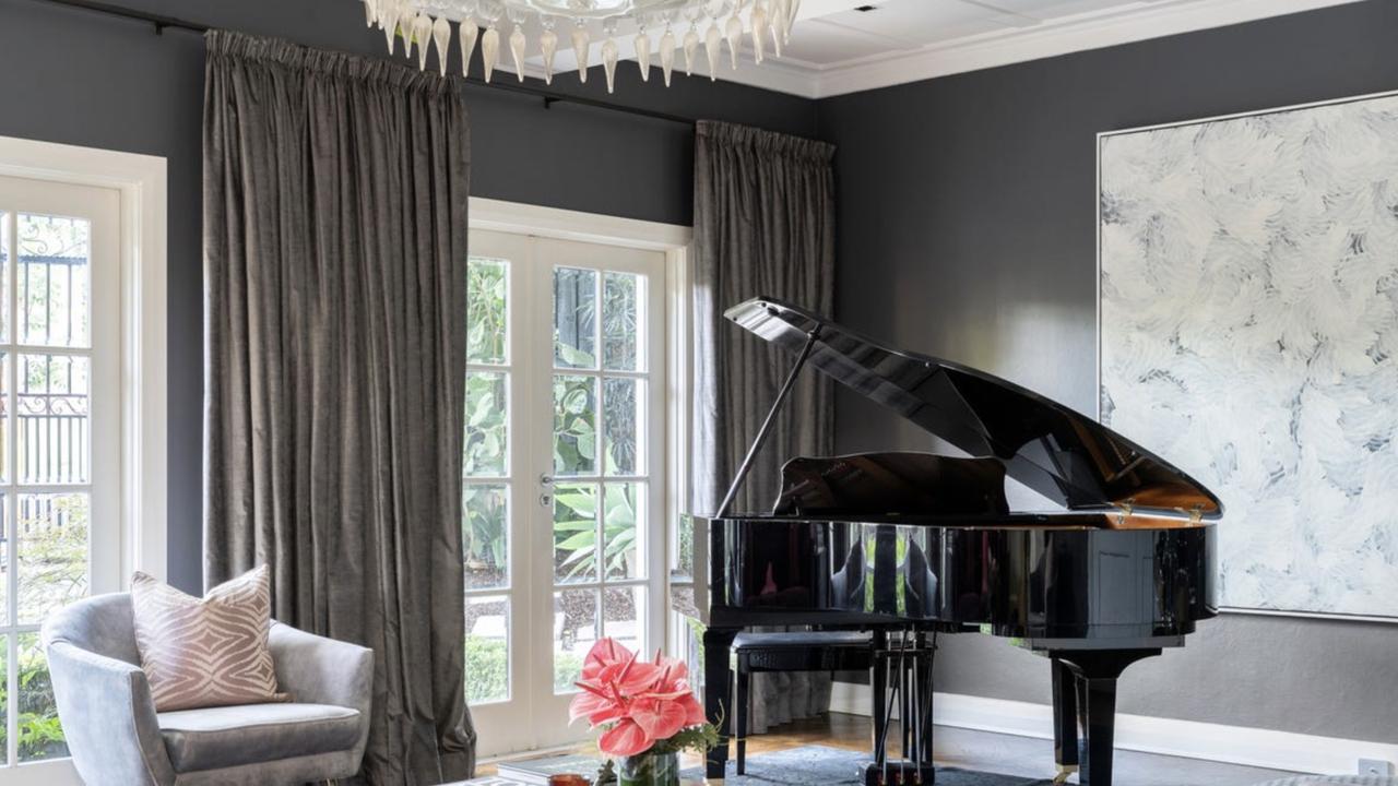A glamorous music room with grand piano and French doors adds timeless elegance to the Toorak residence.