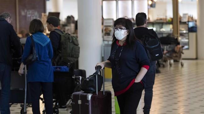 People arriving and wearing mask at Brisbane International airport. (AAP Image/Attila Csaszar)