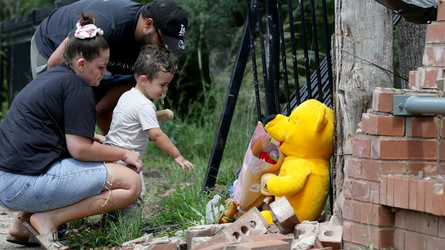 Tremaine Francis Sr, the older brother of Sheldon and Shane Shorey, with his son Tremaine Francis Jr and partner Kiarna Peachey visited the scene on Warne St. Picture: Jonathan Ng