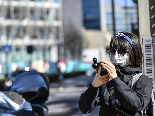 A woman wears a mask as she takes photos in Milan, Italy. Picture: AP