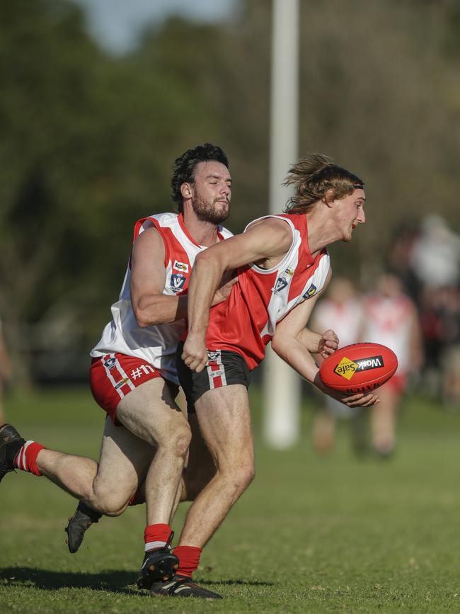 Karingal’s Steve Mihevc (left) tackles Red Hill’s Luke Marchesani last season.