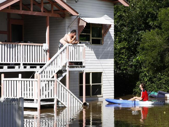 Flooding in Brisbane after heavy rains. Liam Parker chats to a neighbour in Fenton street in Fairfield. His number is 0455 024 174, happy to chat. Picture: Tertius Pickard