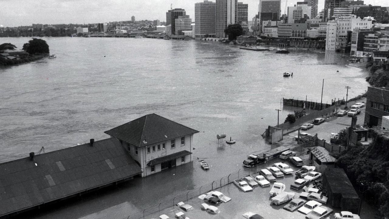 The swollen Brisbane river with the CBD skyline in the background.