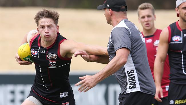 Jack billings fends off assistant coach Aaron Hamill at St Kilda training.