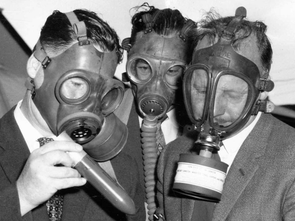 Police in South Australia. Gas-masked members of the CIB demonstrate a new tear gas riot gun at Fire Brigade headquarters. (L-r) Detective D. O'Doherty, Detective-Sergeant L. Harper, Detective-Sergeant L. Brown and Detectives J. Zeunert and B. Stewart 24 Oct 1959. (Pic by staff photographer Brian Kempton)