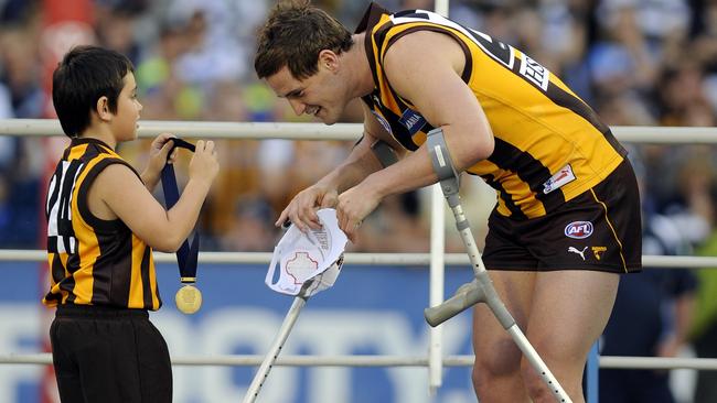 Trent Croad, on crutches, receives his 2008 premiership medallion.