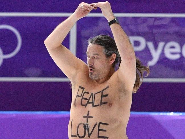 A shirtless man clad in a tutu dances on the rink following the men's 1,000m speed skating event medal ceremony during the Pyeongchang 2018 Winter Olympic Games at the Gangneung Oval in Gangneung on February 23, 2018. / AFP PHOTO / Mladen ANTONOV