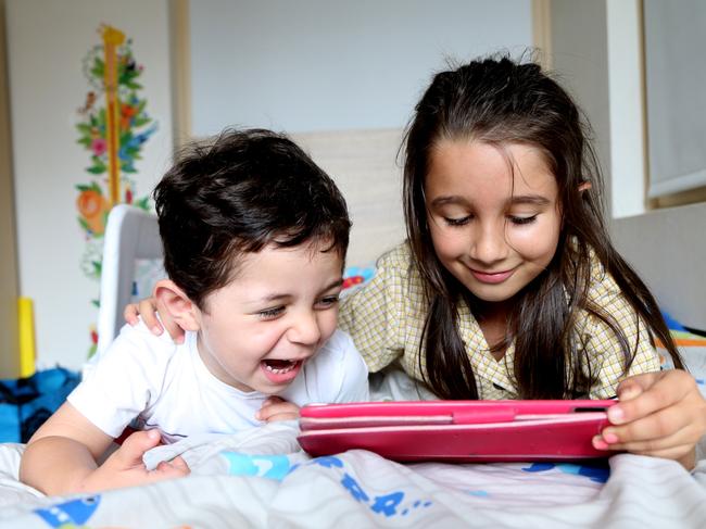 Gideon Heik with sister Ariella playing with his iPad under controlled conditions. Picture: Adam Taylor