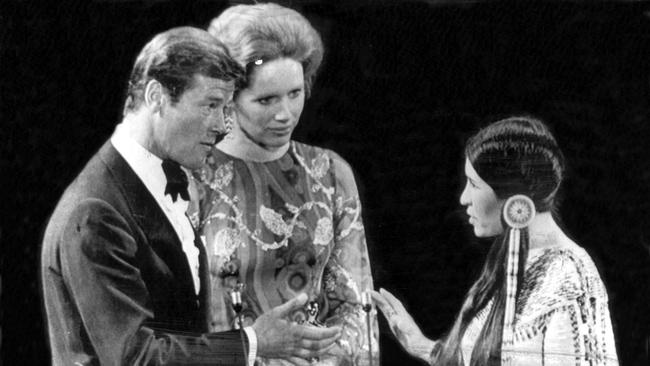 Sacheen Littlefeather holds her hand out to Liv Ullmann and Roger Moore to refuse Marlon Brando’s Oscar. Picture: AP