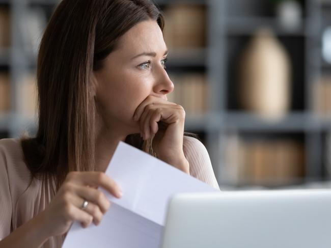 MONEY ISTOCK -  Head shot stressed young woman holding paper document, bank debt notification, thinking of financial troubles, looking away. Lost in negative thoughts depressed woman worrying about bad news notice. Picture: Istock