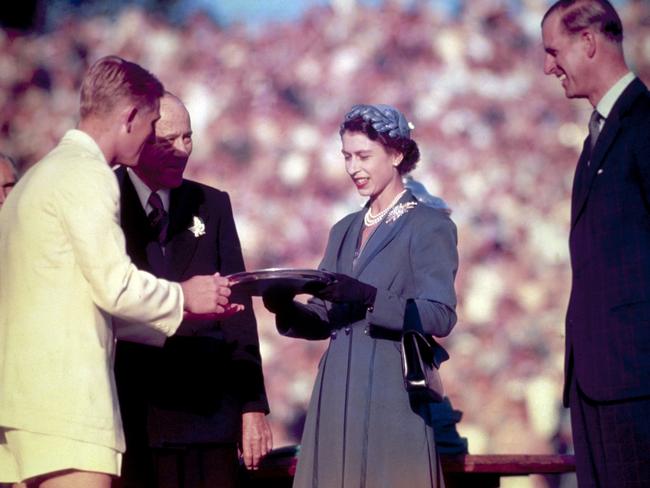 Queen Elizabeth II presents the Silver Salver to Australian tennis champion Lewis Hoad in 1954 as Prince Philip looks on. Picture: Hulton Archive/Getty Images