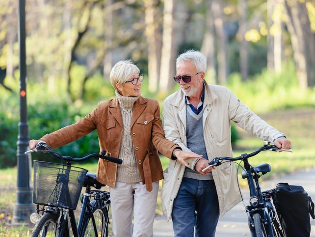 SENIOR/PENSIONER/MATURE/ELDERLY/OVER 65/GRANDPARENT/RETIREE/SUPERANNUATION. Picture: istock Cheerful active senior couple with bicycles walking through park together. Perfect activities for elderly people.