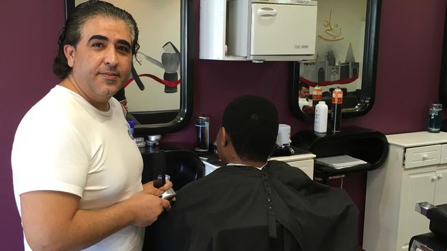 Local barber Amin Eslamizadeh said he would like to see more locals frequenting the Racecourse Rd shopping strip. Picture: Darren Cartwright