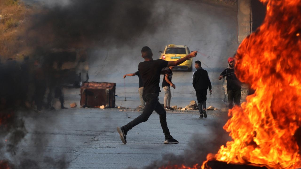 A Palestinian demonstrator throws rocks towards Israeli soldiers during clashes in the city of Ramallah in the occupied West Bank. Picture: Jaafar Ashtiyeh/AFP