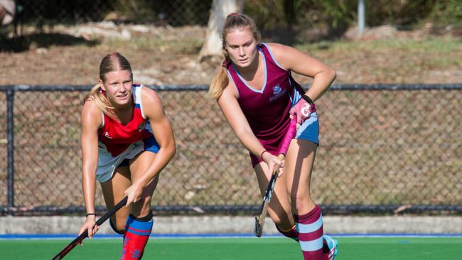 University of Queensland Hockey Club's Morgan Gallagher (right) passes the ball away from Kedron Wavell's Jemma Punch. Photo by Andrew Blanchard.