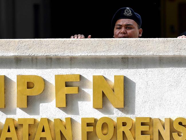 A Malaysian Police personnel looks over the wall from the forensic wing at Hospital Kuala Lumpur where the body of Kim Jong-Nam is being kept. Picture: AFP/Manan Vatsyayana