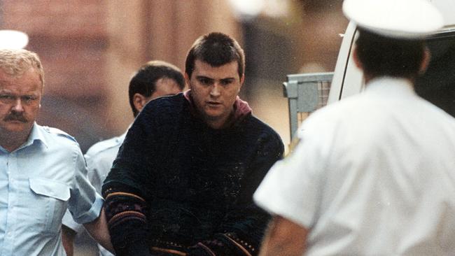 Frankston killer Paul Denyer is escorted by police.