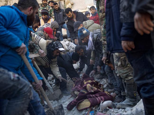 Residents retrieve a body from the rubble of a collapsed building in the regime-controlled town of Jableh in the province of Latakia, northwest of the capital Damascus. Picture: AFP