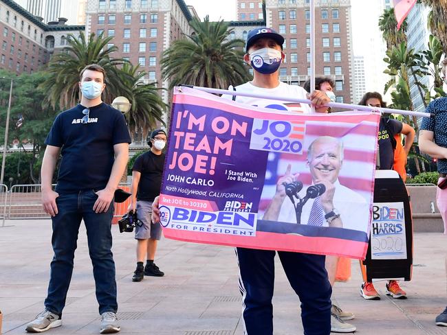 John Mena holds a Joe Biden flag as he stands with activists gathered for a rally in downtown Los Angeles, California. Picture: AFP