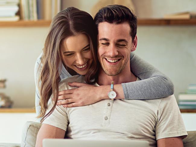 A husband and wife using their computer on the couch at home. Picture: iStock.