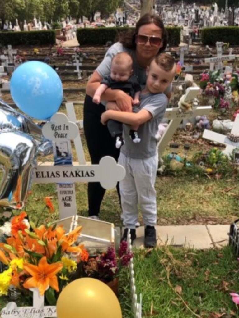 Elizabeth Kakias with baby Alexander and son Romeo at Elias' grave. Picture: Supplied