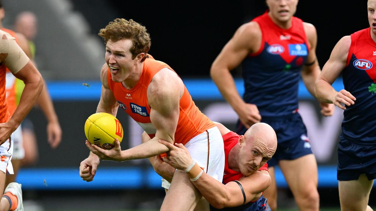 MELBOURNE, AUSTRALIA - MARCH 16: Tom Green of the Giants handballs whilst being tackled by Aidan Johnson of the Demons during the round one AFL match between Melbourne Demons and GWS Giants at Melbourne Cricket Ground, on March 16, 2025, in Melbourne, Australia. (Photo by Quinn Rooney/Getty Images)