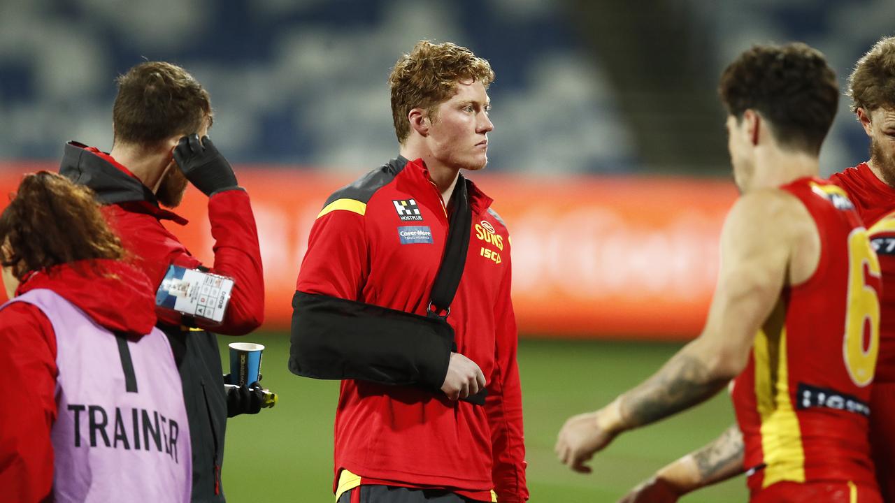 GEELONG, AUSTRALIA - JULY 04: Matthew Rowell of the Suns is seen with his arm in a sling during the three quarter time huddle during the round 5 AFL match between the Geelong Cats and the Gold Coast Suns at GMHBA Stadium on July 04, 2020 in Geelong, Australia. (Photo by Daniel Pockett/Getty Images)