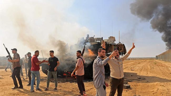 Palestinians take control of an Israeli tank after crossing the border fence with Israel from Khan Yunis in the southern Gaza Strip on October 7, 2023.