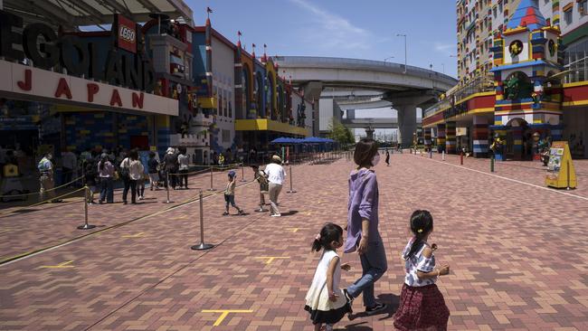 Visitors wearing face masks walk outside the entrance to the Legoland Japan theme park in Nagoya, Japan. Picture: Getty Images