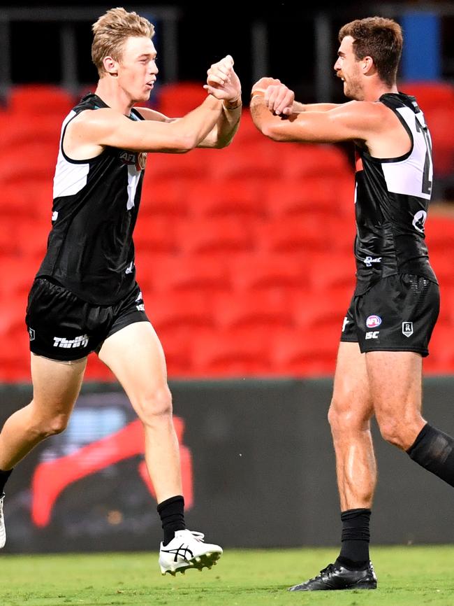 Power key forward Todd Marshall (left), one of the club’s interstate recruits, celebrates kicking a goal against Gold Coast in round one with teammate Scott Lycett. Picture: Darren England (AAP)