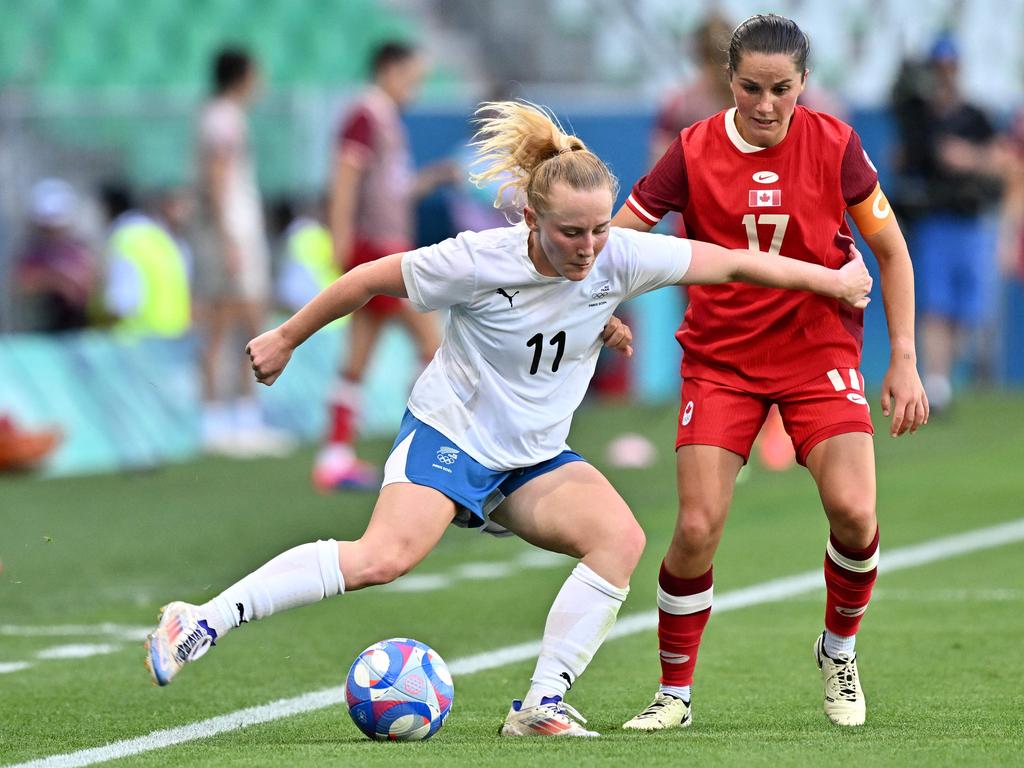 New Zealand's midfielder Katie Kitching and Canada's Jessie Fleming fight for the ball in their opening match. Picture: AFP