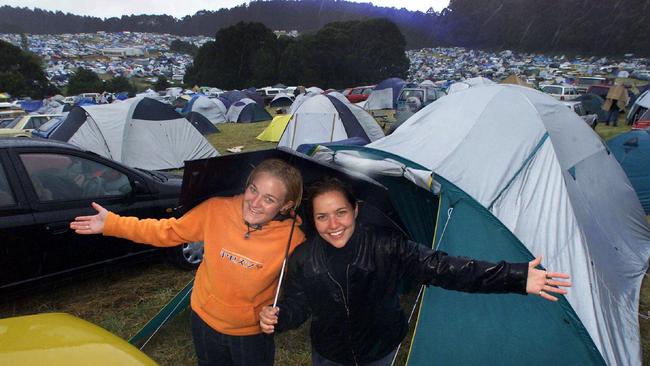 2001: Lauren and Simone camp take shelter from the rain along with hundreds of other festival goers. Picture: HWT Image Library.