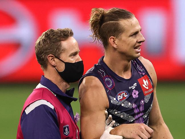 PERTH, AUSTRALIA - JUNE 06: Nat Fyfe of the Dockers is assisted  from the field by the club doctor with a shoulder injury during the round 12 AFL match between the Fremantle Dockers and the Western Bulldogs at Optus Stadium on June 06, 2021 in Perth, Australia. (Photo by Paul Kane/Getty Images)