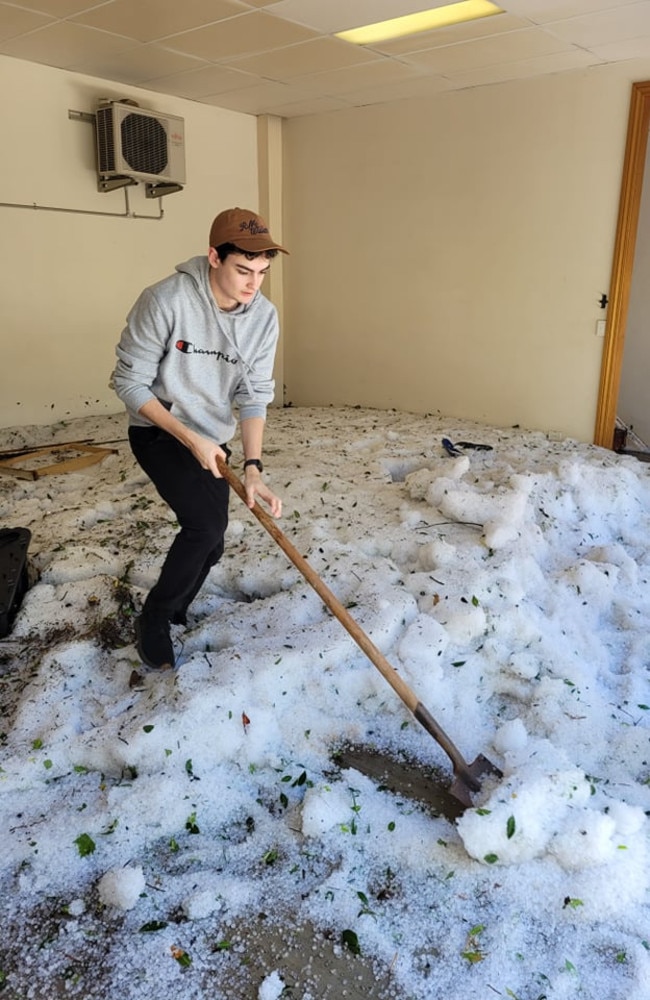 Travis Fielder sweeps away mountains of hail after a storm blew through Toowomba on Saturday night.