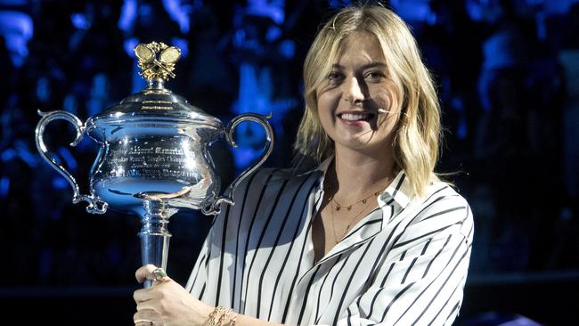 Former ladies single's champion Russia's Maria Sharapova poses for a photo with the Daphne Akhurst Memorial Cup on Margaret Court Arena during the ceremony for the official draw at the Australian Open tennis championships in Melbourne, Australia Thursday, Jan. 11, 2018. (AP Photo/Mark Baker)