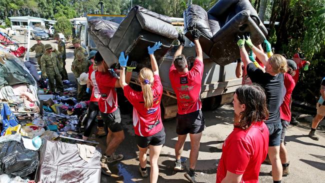 An army of volunteers from the Port Macquarie Pirates Rugby Union team along with RFS and ADF 6th Battalion RAR from Brisbane help clean up continues at the Riverside Village Residential Park in Port Macquarie. Picture: Nathan Edwards