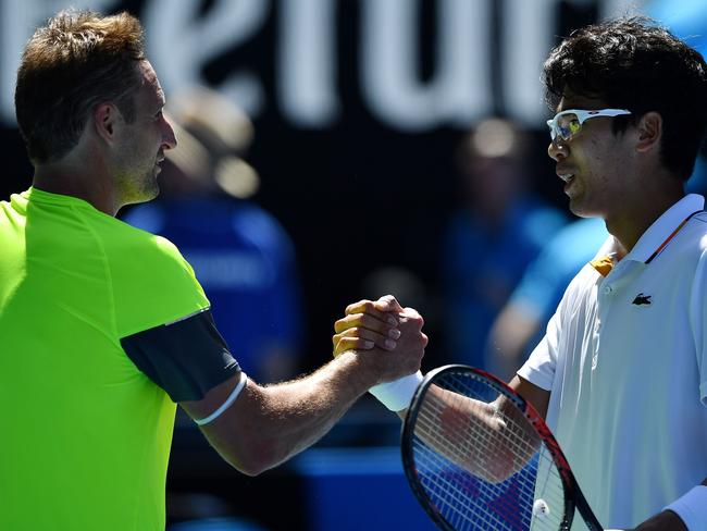 The two unseeded players shake hands at the net.