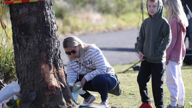 A woman lays flowers at the crash scene. Picture: John Grainger