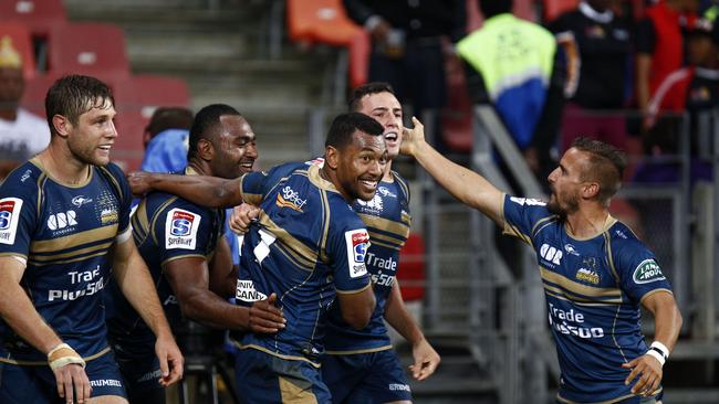 Brumbies players celebrate after scoring a try.