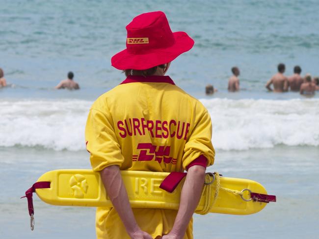 Mooloolaba, Australia - February 11, 2007: Lifesaver patrols Moloolaba Beach on the Sunshine Coast, Queensland. He can be seen holding a flotation device (rescue tube) behind his back. Swimmers can be seen in the water.Escape 20 August 2023Why I TravelPhoto - iStock