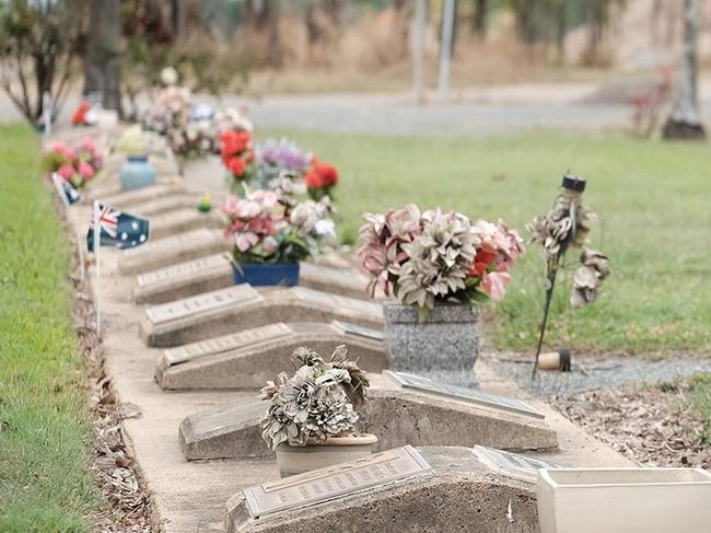 NOT FORGOTTEN: Lyn Burke places flags on soldiers' graves at the Proserpine Cemetery ahead of Remembrance Day next Wednesday. Photo Matthew Newton / The Guardian