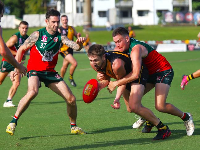 Pictured: Tiger Darcy Keast disposes of the footy while tackled by Cutter Alex Rogers. South Cairns Cutters v North Cairns Tigers at Cazalys Stadium. Qualifying Final. AFL Cairns 2024. Photo: Gyan-Reece Rocha