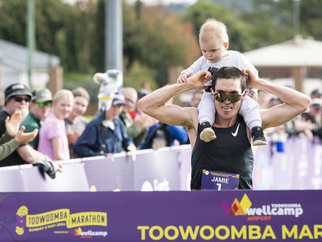 Toowoomba Marathon winner Jamie Lacey collected his one-year-old son Jackson Lacey before crossing the finish line, Sunday, May 5, 2024. Picture: Kevin Farmer