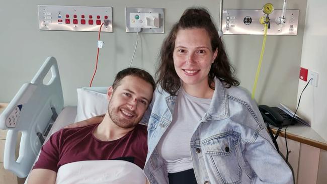 Constable Randall Kirk, pictured with wife Bree, in hospital after surgery to remove shrapnel and repair injuries sustained when intense fire from a variety of weapons was directed towards him during the incident at Wieambilla on Monday. Source - Queensland Police Union of Employees.